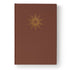 Bíblia Pastoral, capa dura marrom com detalhes dourados em formato de sol radiante. — Plenitude