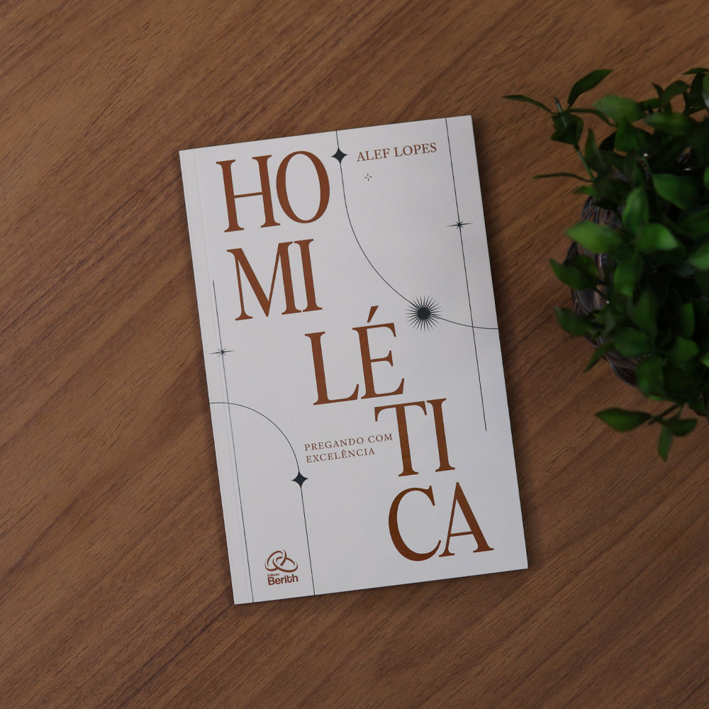 Livro Homilética de Alef Lopes apoiado sobre a mesa, ao lado de uma planta